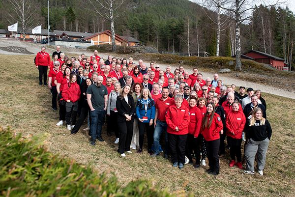 Informasjon om Telemark Røde Kors. Bilde av en gjeng frivillige på en gressplen