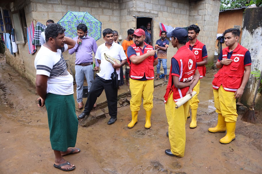 Hjelpearbeidere informerer landsbybeboere etter flommen.