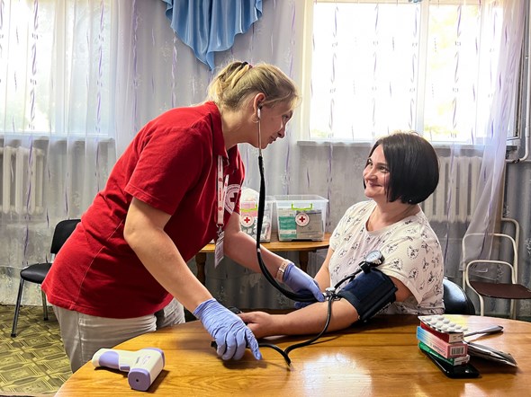 En sykepleier måler blodtrykk poet mobilt helsesenter i Ukraina.