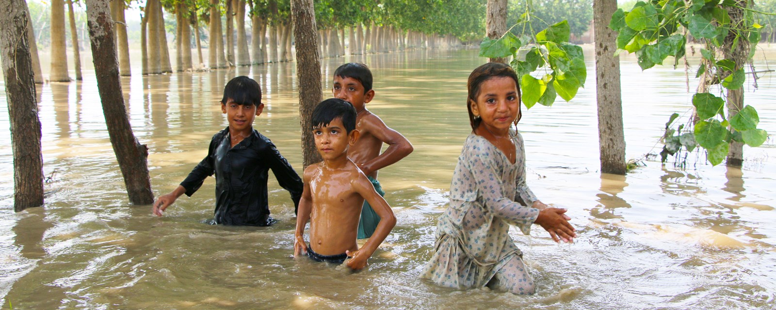 Barn i flomvann i Pakistan. 