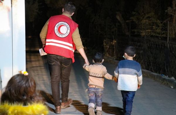 En mann fra Syrisk Røde Halvmåne leier to små barn