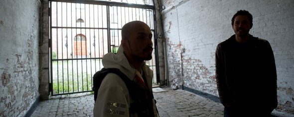 Bildet viser to personer som snakker sammen foran en fengselsport.