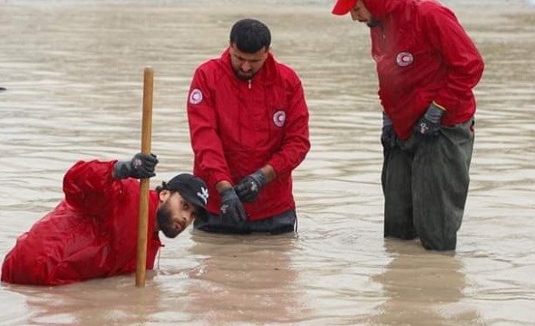 Mannskap fra Røde Kors står i flommen