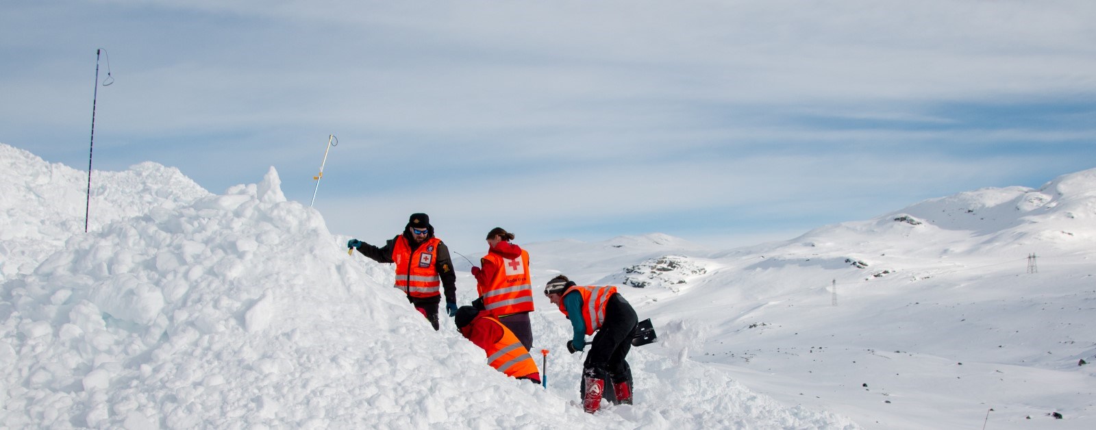 Fire personer graver i en snøhaug