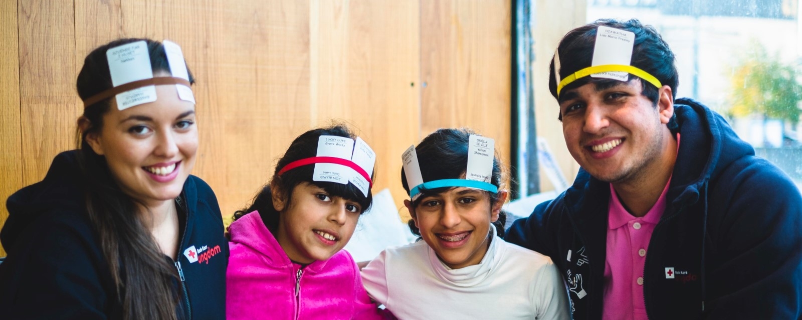 Røde Kors Ungdom-frivillige spiller kortskalle med to barn