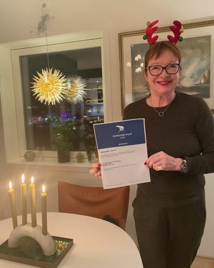 Gerd mottar gavekort fra Nordisk film, hun står i et julepyntet rom