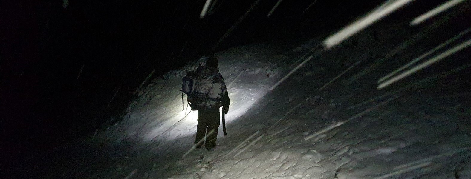 Røde Kors hjelpekorps ute i snøstorm i mørket.