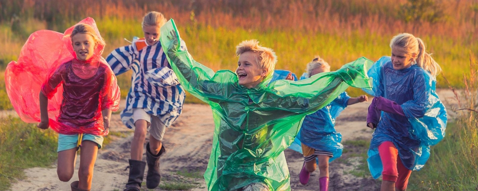 Glade barn som løper i regnet