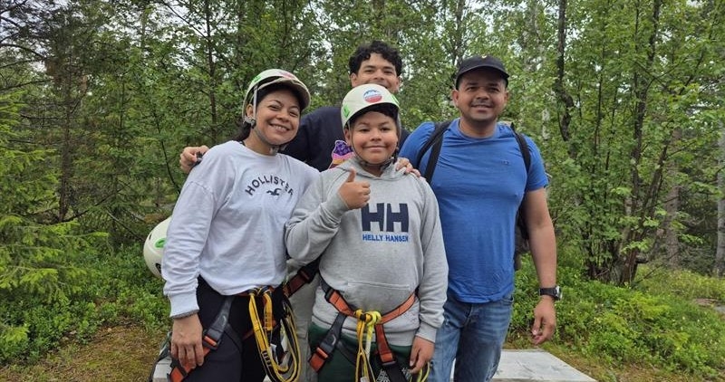 Fire mennesker med klatreutstyr på seg smilende mot kamera