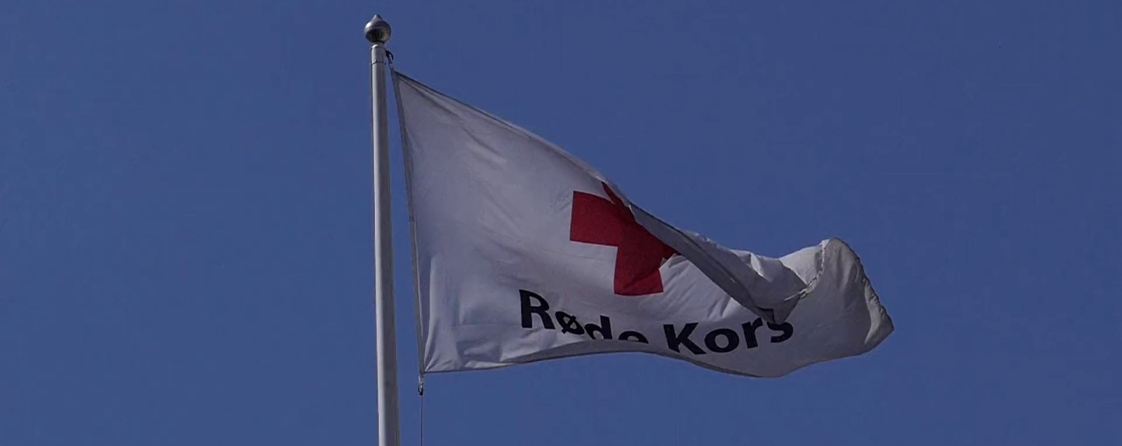 Røde Kors-flagget vaier i vinden.