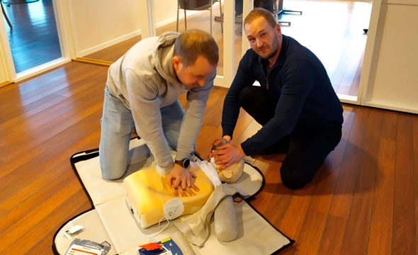 To menn øver på førstehjelpsdukke