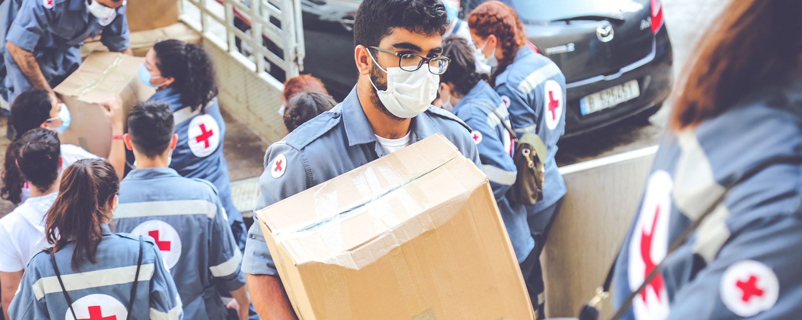 En frivillig fra Røde Kors bærer en kasse
