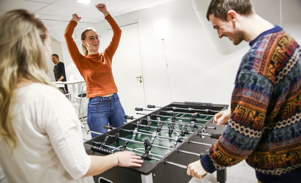 Bilde fra trondheim røde kors fellesverket viser ungdom i samtale ved bord og ungdom som spiller fussball