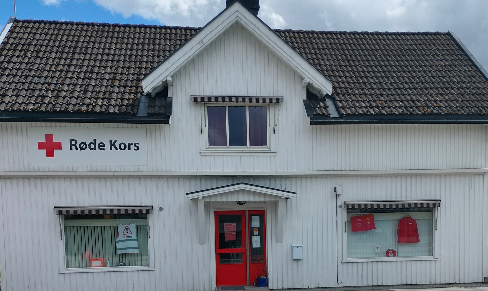 Et hvitt hus med Røde Kors-logo