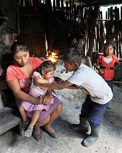 Mor og barn i hytte ved ildsted