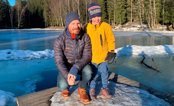 Gutt og mann ved tjern i skogen