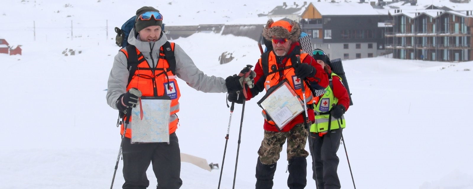 tre skigåere fra Røde Kors hjelpekorps utendørs på Finse