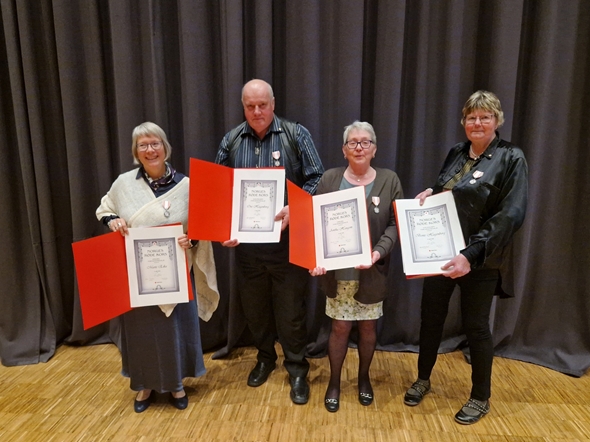 Fire mennesker som holder opp sine æresbevisninger