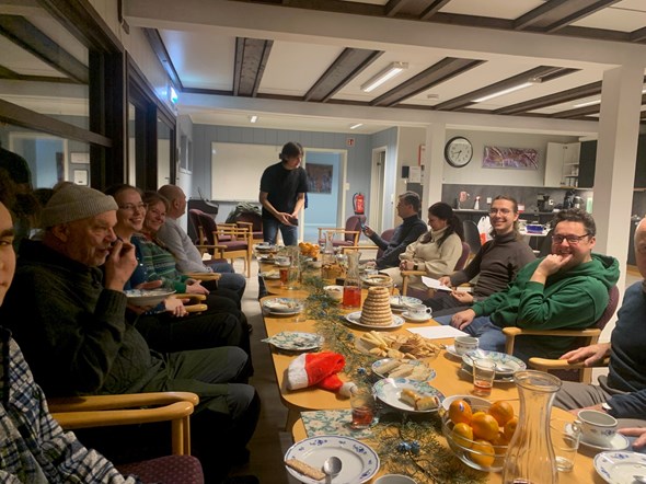 En gruppe mennesker sitter rundt et bord  og spiser kake