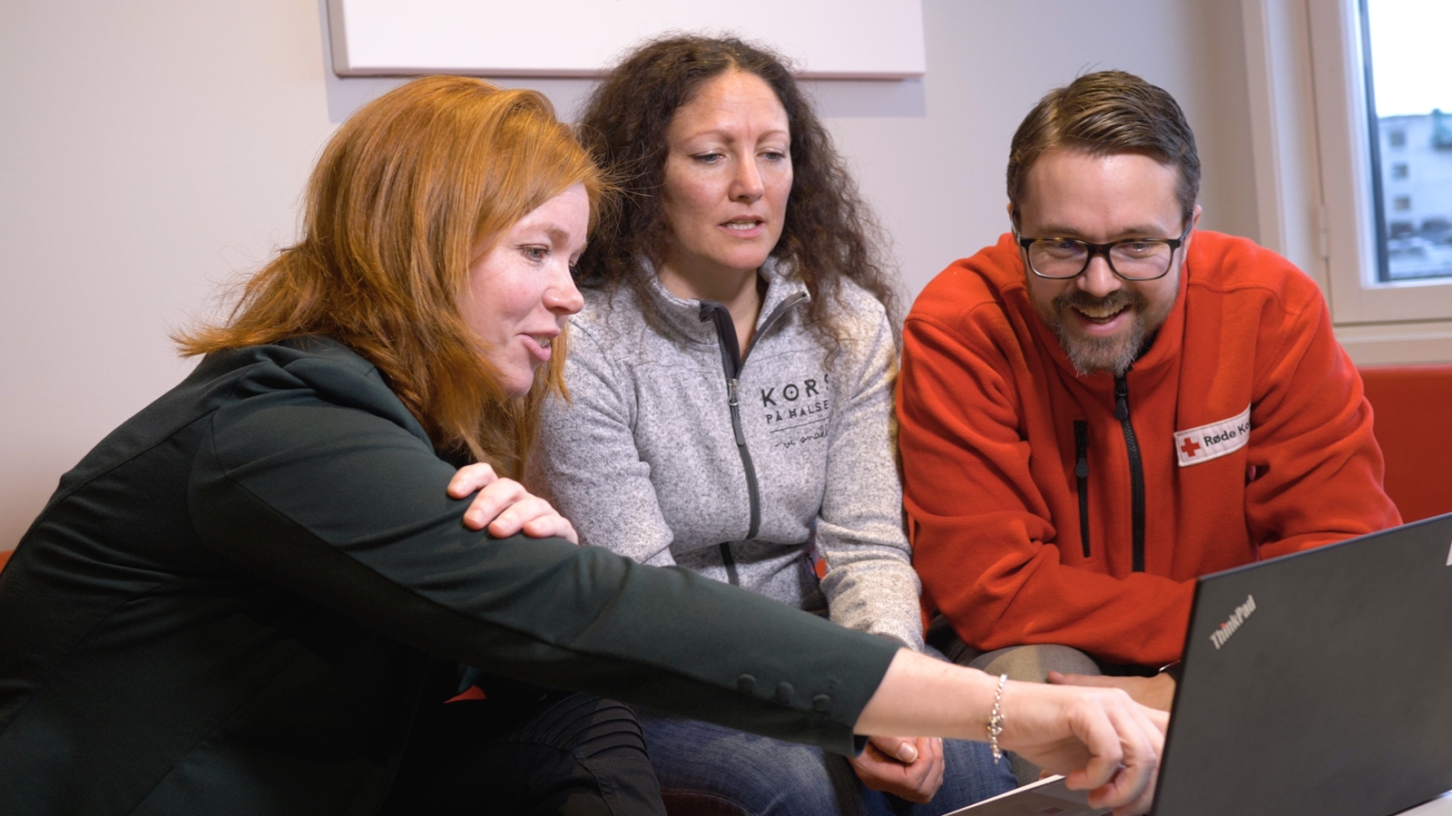 Tre menensker ser på skjerm