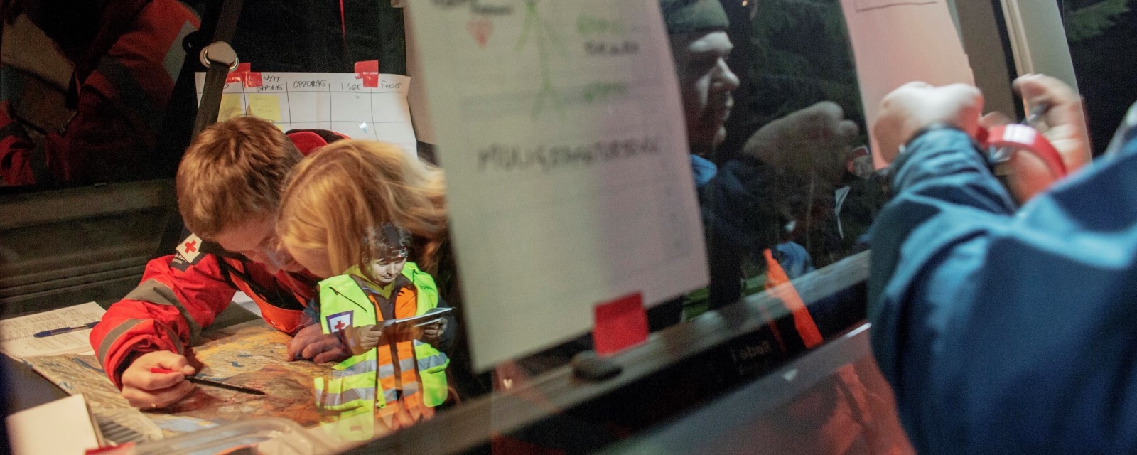 Mennesker jobber med kart og situasjonsbilde i en beredskapsøvelse