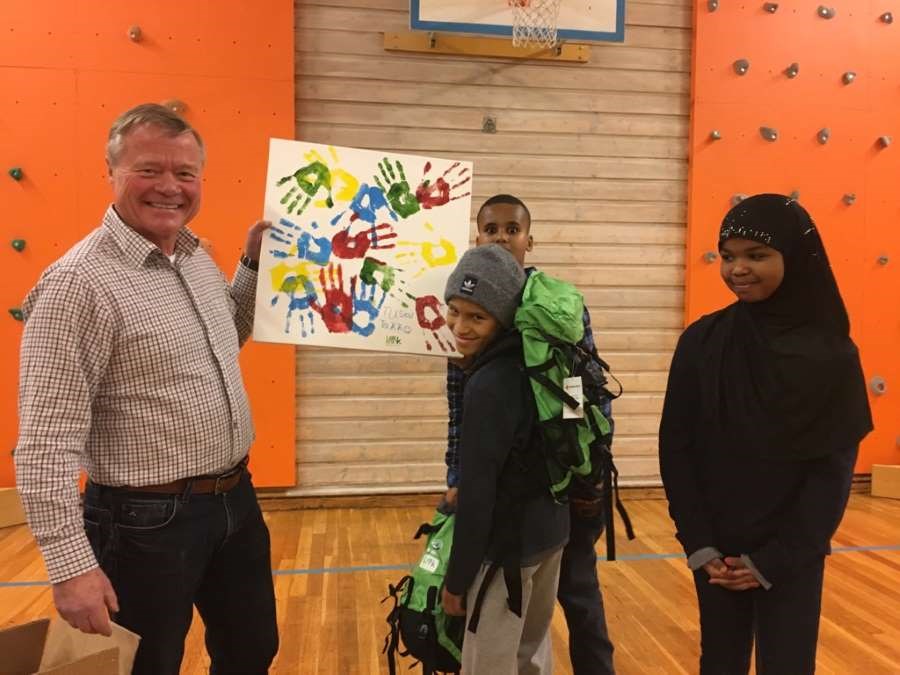 Smilende Torbjørn Johannson viser maleri med to barn på skole