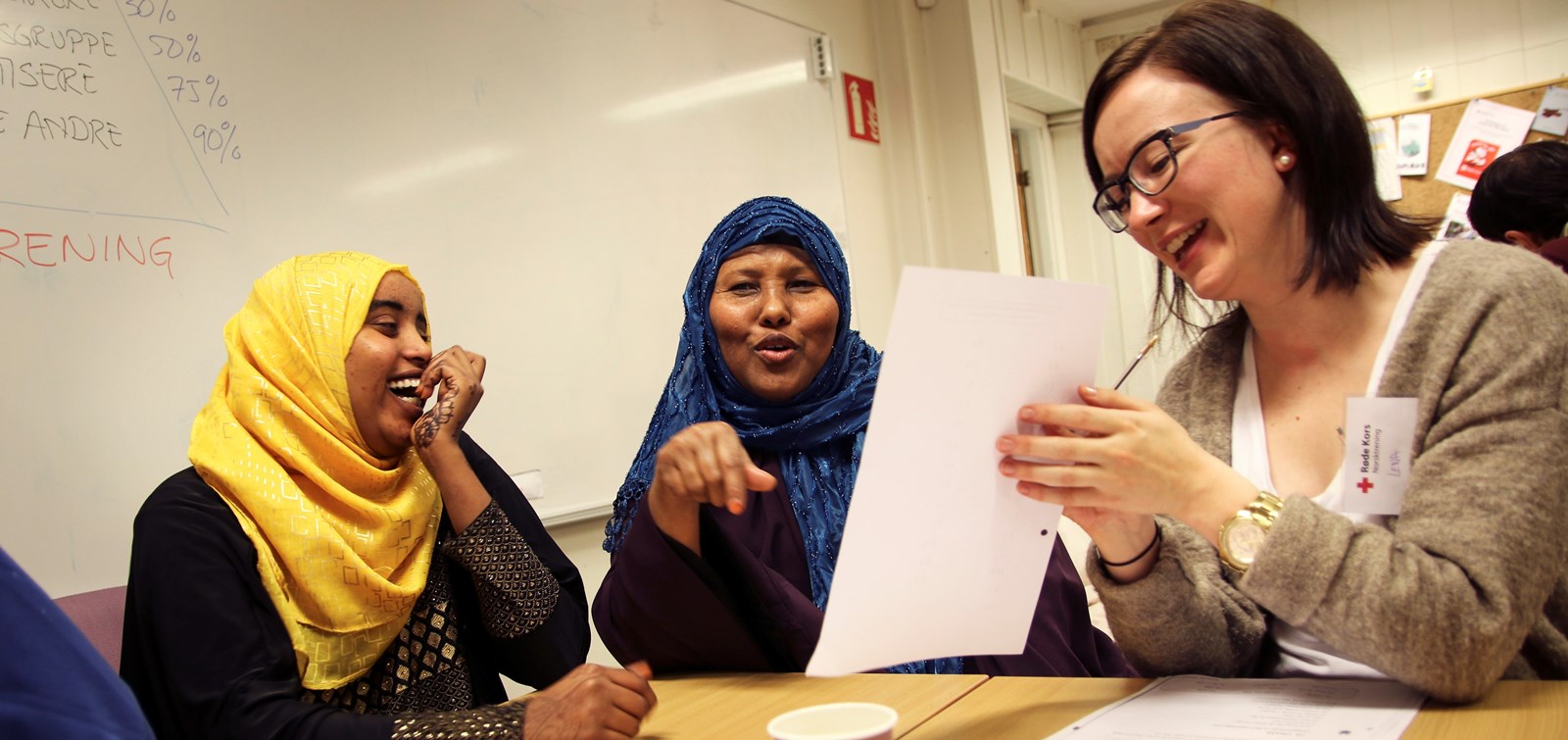 2 somaliske kvinner i klasserom med hvit tavle bak