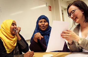 2 somaliske kvinner i klasserom med hvit tavle bak