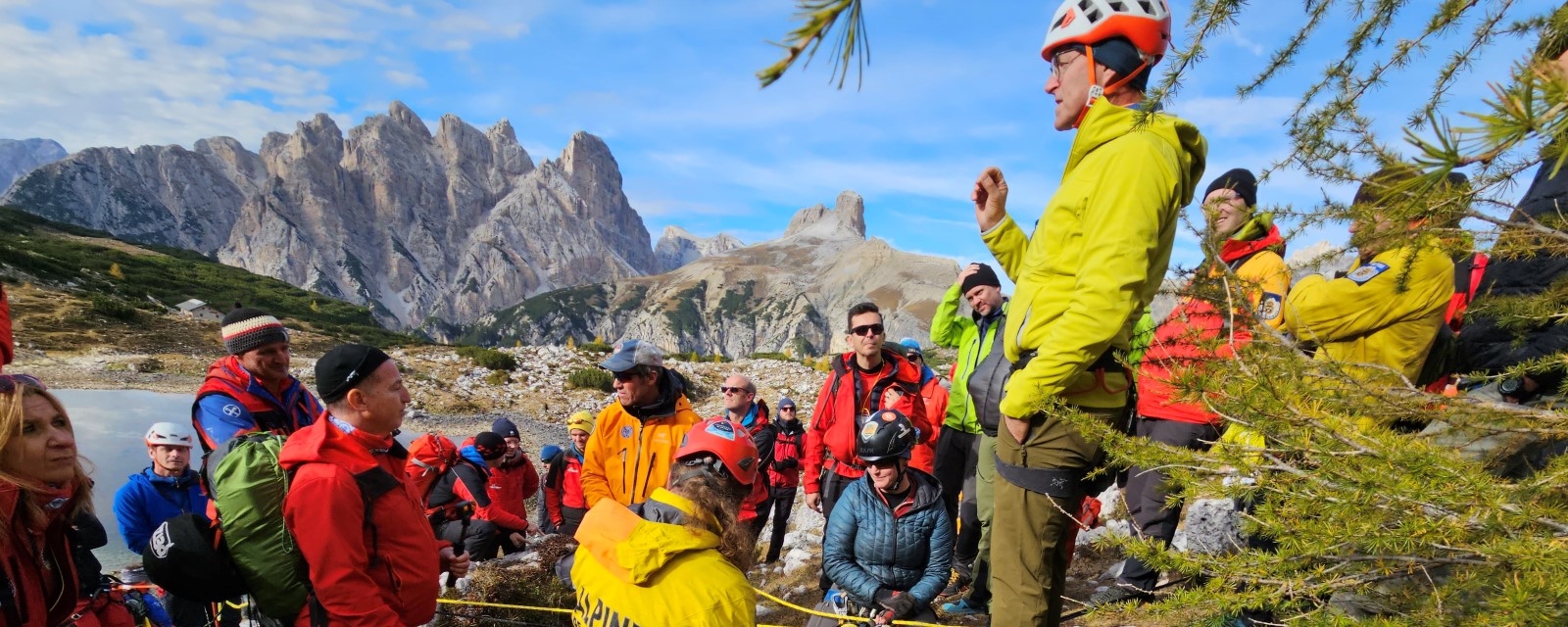 En gruppe mennesker står på en høyde med fjellandskap i bakgrunnen.