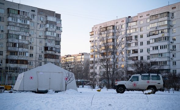 Mann sitter med ryggen til og snakker med smilende barn