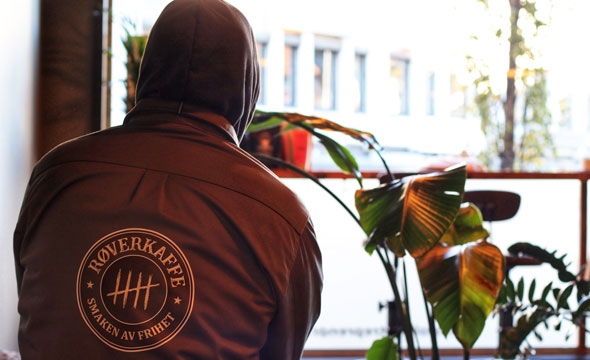 Mann sitter på kafe med ryggen til