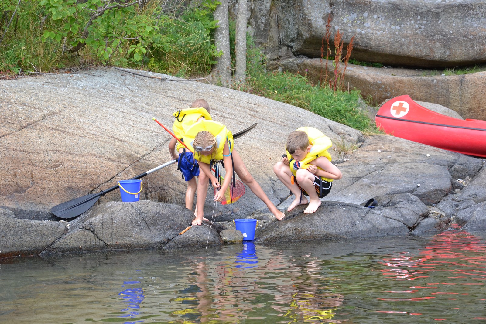 Bilde av barn som leker langs vannet på ferieleir med Telemark Røde Kors 