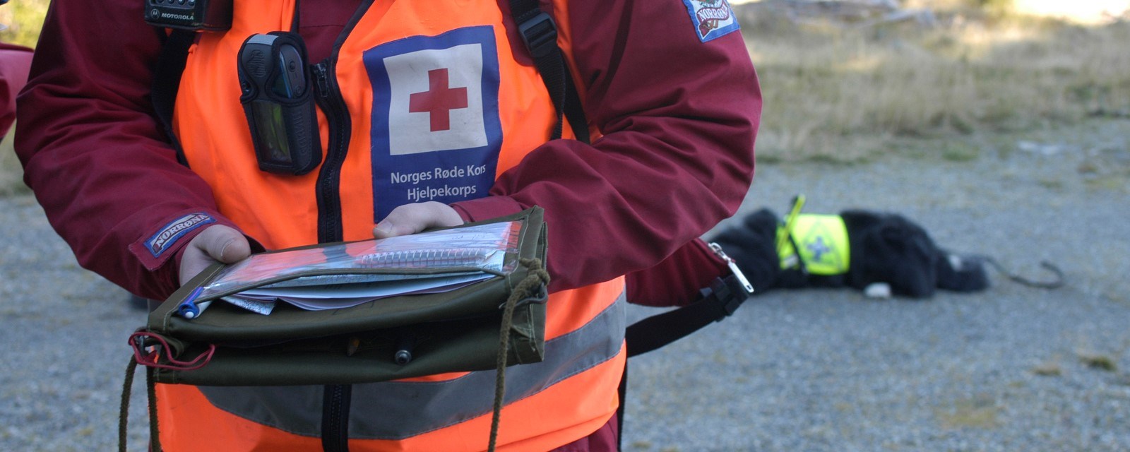 En person med hjelpekorpsuniform holder et kart