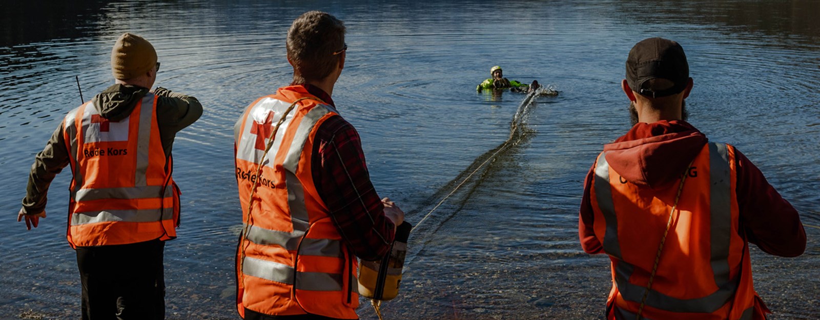Tre hjelpekorpsere øver på å redde en person i vannet