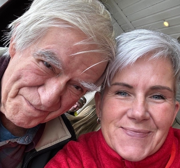 En kvinne og en eldre mann som smiler inn i kamera.