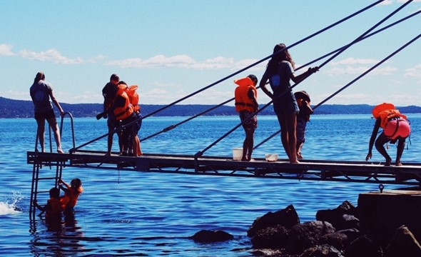 Barn som leker på brygga i det fine sommerværet