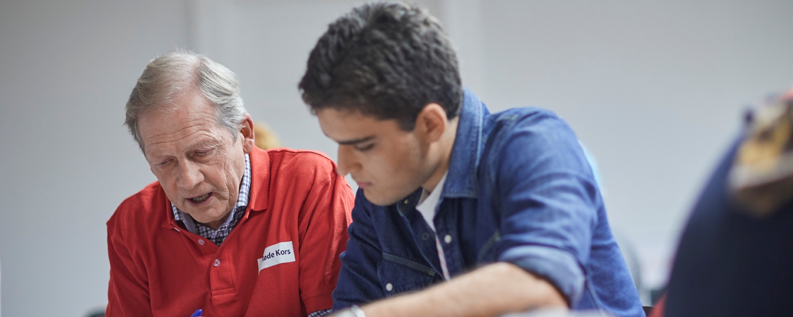 En voksen og en ung mann i undervisning