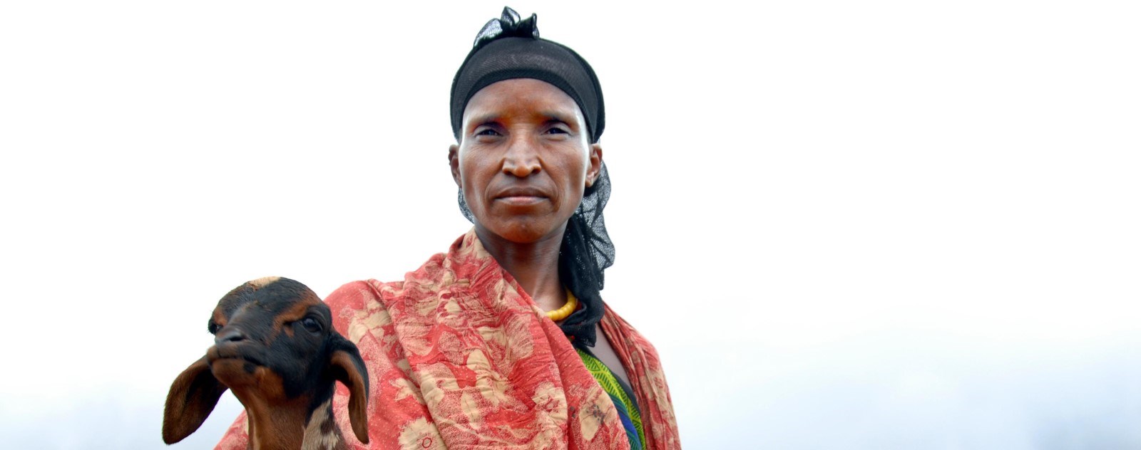 En etiopisk kvinne holder en geit