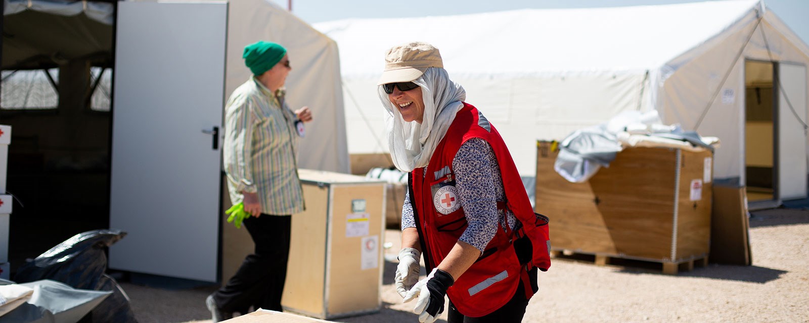 En kvinnelig Røde Kors delegat i flyktningleir jobber i stekende sol