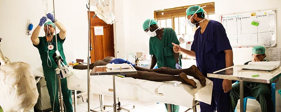 Kirurgisk team forbereder operasjon på pasient med skuddskader