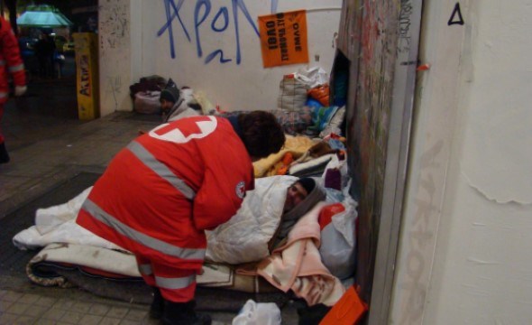 Foto Røde Kors frivillige hjelper flyktninger som sover på gaten i Hellas