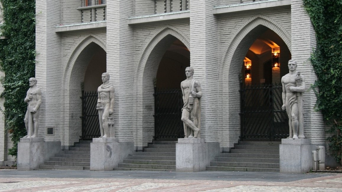 Viser bygning med skulpturer i inngangsparti