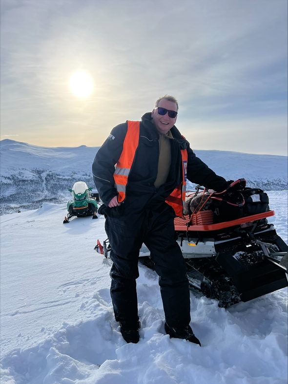 En mann ute i snøen på fjellet.