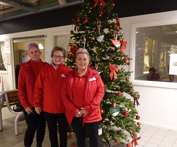 Tre Røde Kors-kvinner foran et juletre.