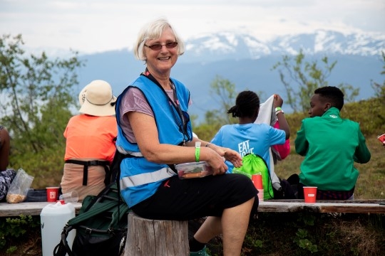 Kvinne sitter på benk ute.