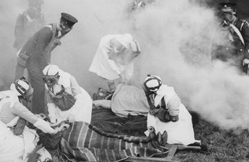 Helsepersonell og soldater iført gassmasker står bøyd over pasienter under en øvelse fra Storbritannia på 30-tallet