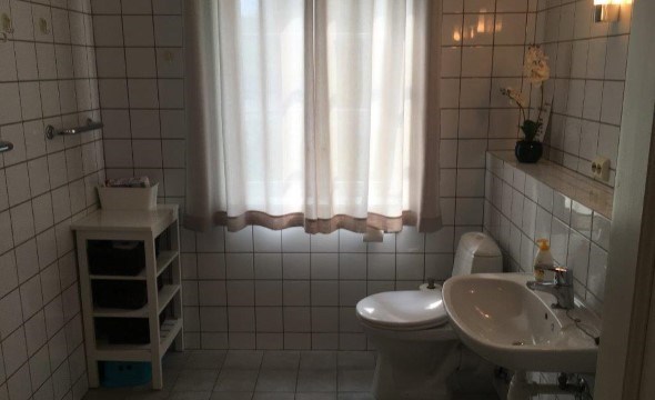 Badet på Solvik med toalett, vask og hyller.