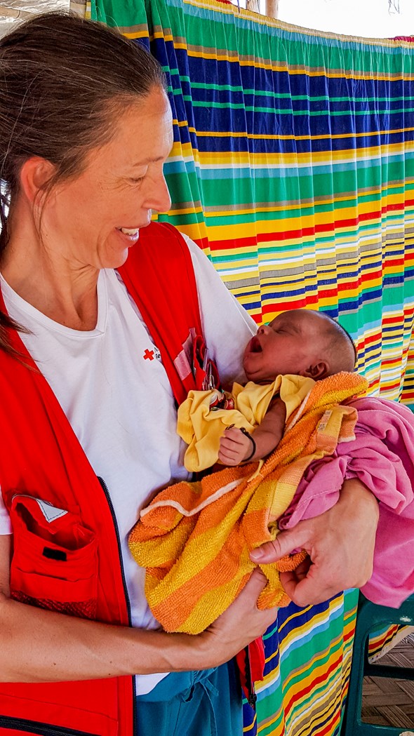 Bildet viser delegaten Nina som holder en liten baby, som bor i flyktningleiren hvor Nina jobber på et feltsykehus.