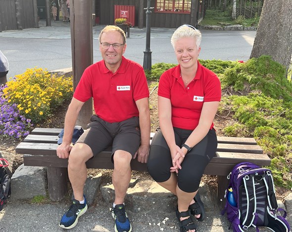 To frivillige, en mann og en kvinne, på en benk på Hunderfossen.