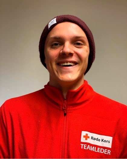En mann med Røde Kors genser smiler til kamera